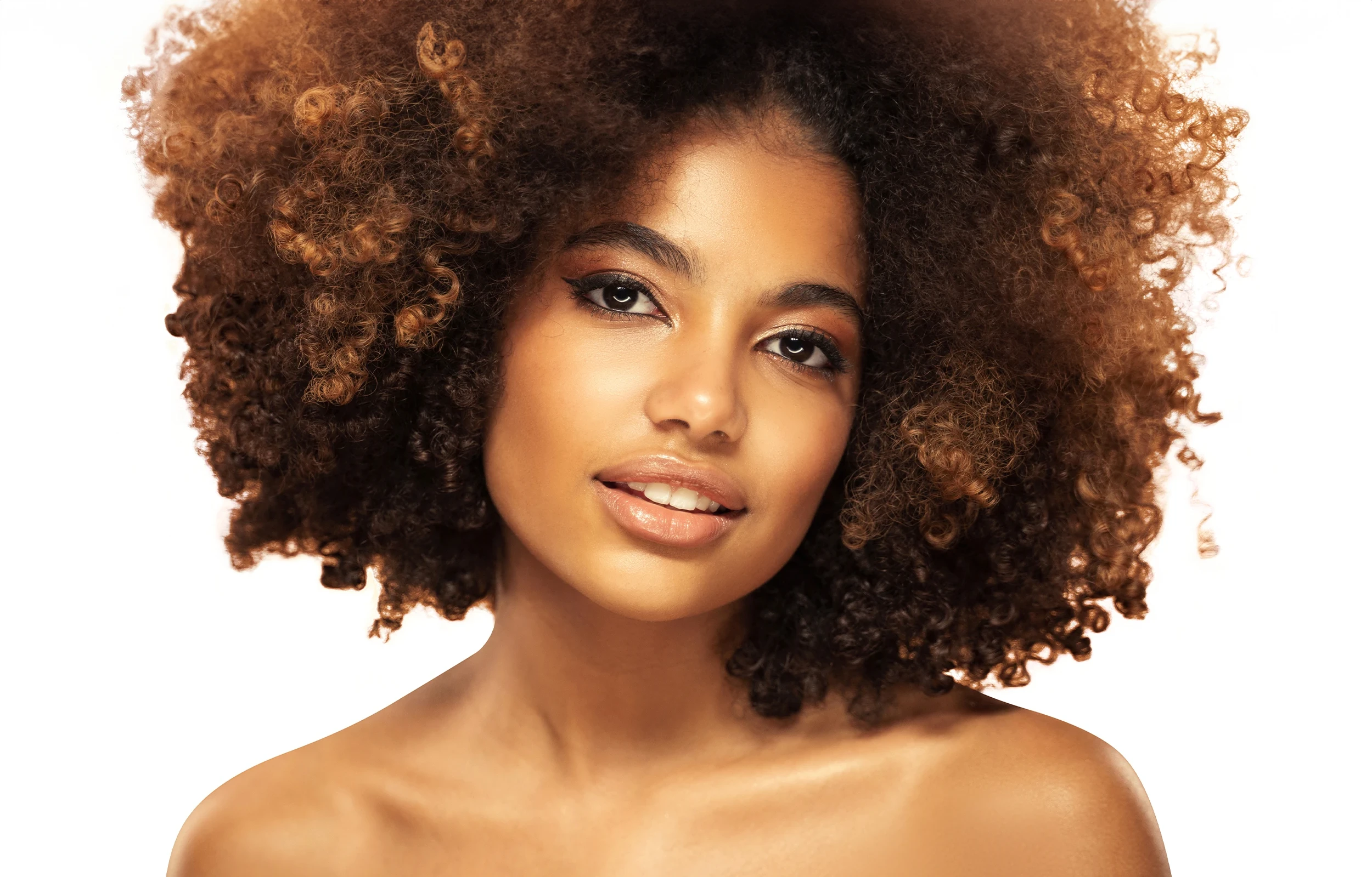 Portrait of a woman with radiant, glowing skin and voluminous natural curls